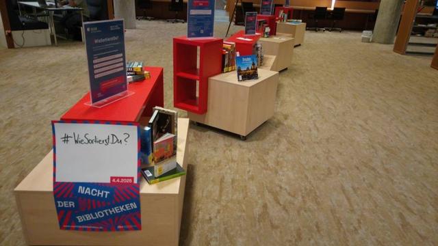 Kleine Regale mit Büchern, die nach unterschiedlichen Kriterien sortiert sind.