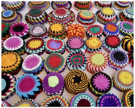 This image shows a collection of colorful traditional nubian hats.