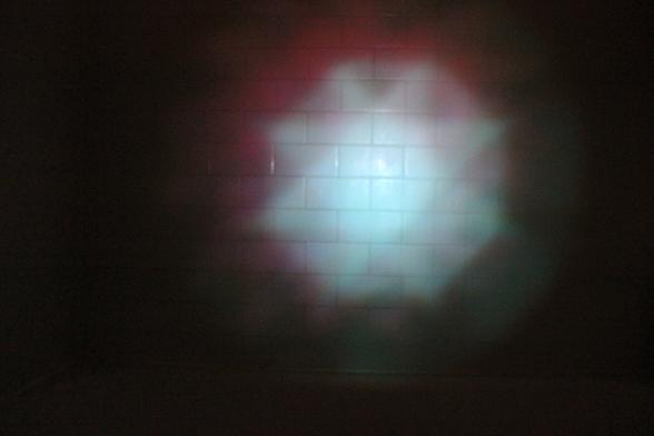 Mysterious reflection on walls of dark bathtub. Centralized orb.
