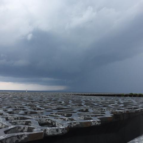 Photo d'un ciel gris lourd et nuageux surplombant la dentelle de béton du Mucem en partie mouillée par la pluie