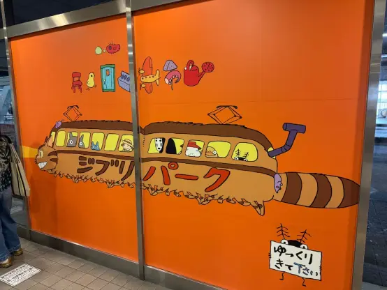 Photo of a sliding door with a large graphic of the Ghobli cat bus on an orange background.