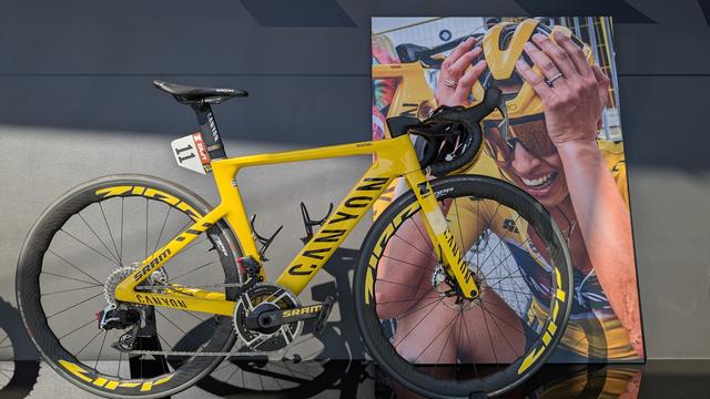 Das gelbe Canyon Aeroad mit der Startnummer 11 von Katarzyna Niewiadoma, mit der sie den Gesamtseig der Tour de France 2024 holte. Am Lenker hängt noch ihr Helm.
Dahinter ist überlebensgroß das sehr emotionale Foto von dem Moment, als sie unmittelbar nach dem Rennen total erschöpft erfährt, dass sie mit nur 4 Sekunden Vorsprung den Gesamtsieg errungen hat.
