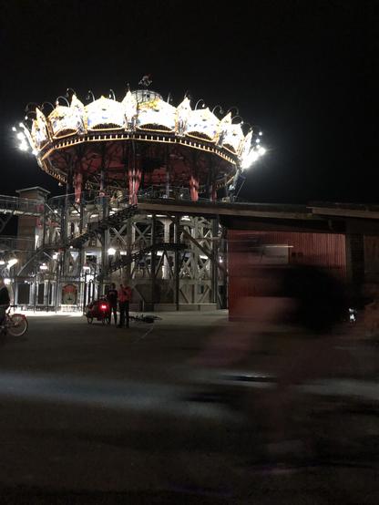 Le carrousel des mondes marins avec au premier plan un cycliste qui passe et dont l’image est rendu floue par la vitesse.