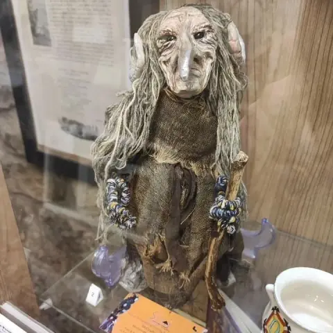 Frau Perchta  - a proud and terrifying mythical witch doll  with horns and long, beak-like nose proudly standing on a display in The Museum of Magic, Fortune-telling & Witchcraft in Edinburgh, Scotland.