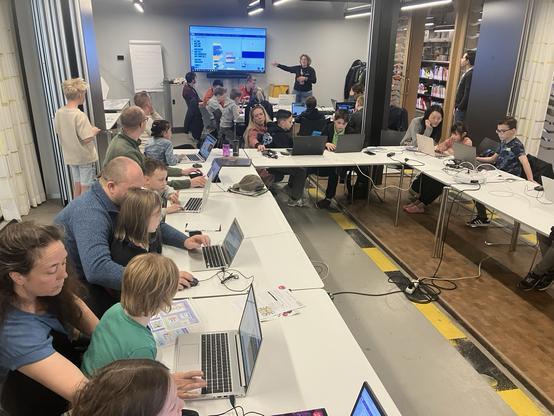 Children with parents learning with Scratch during Coderdojo event at public library Tilburg