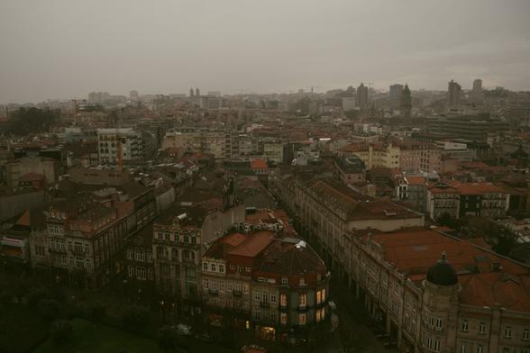 Bild von oben auf Porto bei schlechtem Wetter, grauer Himmel, Nebel am Horizont und Häuser mit roten Dächern sind zu sehen.
