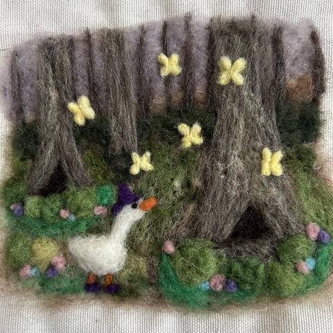 Needle felted painting of a dusky forest with moss and flowers on the ground, where a goose in a purple hat and purple boots looks up in awe at bright yellow fairies fluttering.