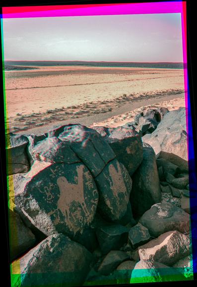 Another photo of the same landscape with more obvious camels on the basalt boulders in the foreground.
