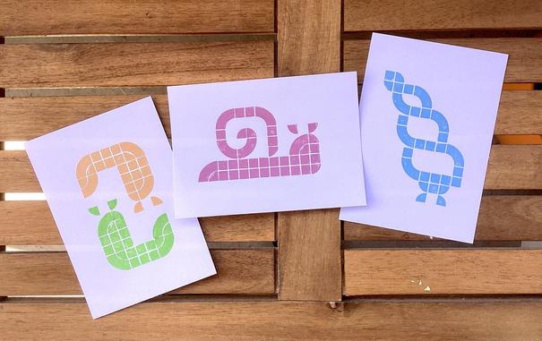 3 postcard sized lego prints:

The first shows a green slug and an orange slug. They are leaning towards each other forming a loose circle shape, looking a bit like the ying yang symbol.

The second is picturing a snail with a shell printed in a muted pink tone.

The third shows a snail peaking out of it's rather long drawn shell. It's based on the shell of Lissachatina fulica.