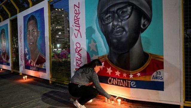 Paola Paiva encén espelmes davant del mural amb el retrat del seu germà, Arturo Suárez, deportat des dels EUA al Cecot d'El Salvador (Reuters/Gaby Oraa)