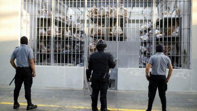 Guàrdies del Cecot d'El Salvador davant una cel·la plena d'interns (Reuters /José Cabezas)