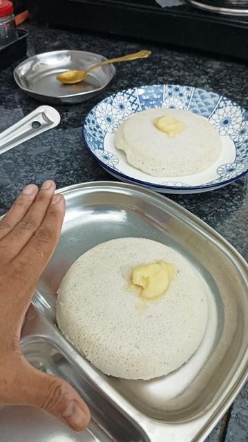 Hand for scale. Just the idli, with a dollop of ghee.