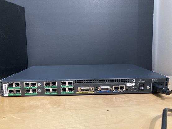 The rear of the cisco 2511. Left: 16 asynchronous RJ45 serial ports that will be connected to external modems. Middle: an AUI ethernet port. Mid-right: Synchronous serial port mini connector, and two RJ45 ports for Console and Aux acces/