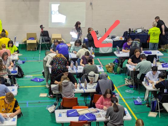 Photo of the hectic pairs puzzling area at UK Nationals today with a big red arrow drawn on top to point at me.