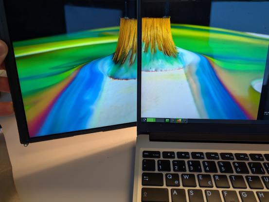 Me holding a naked ipad 3 screen next to my framework 13, while mpv plays some thx test video over both screens.