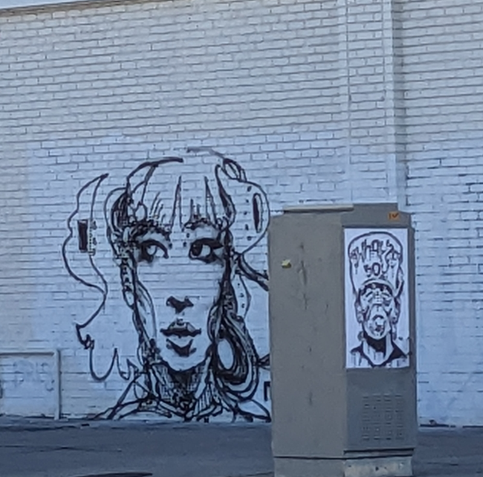 Black and white faces on a wall and utility box