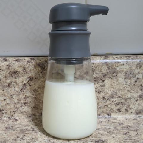Close up photo of OXO Good Grips soap dispenser about 4/5 full of Nivea Super Water Gel Sunscreen from Japan. The dispenser has a clear body and gray top.