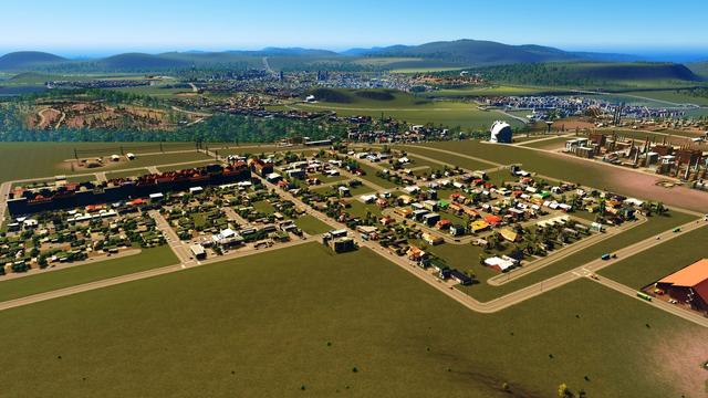 View from a hilltop of a city in the game Cities Skylines
