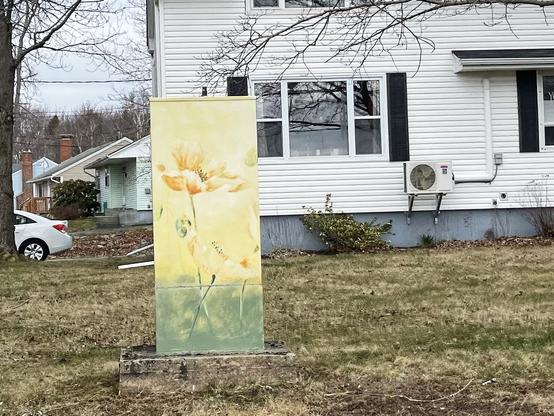 Golden flowers against a yellow background with green grass below. A mural on a utility box at Carver St & Portland St, Dartmouth, Nova Scotia.