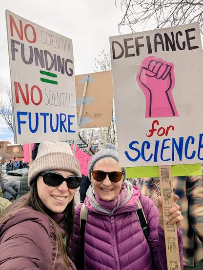 Myself and my mother at the protest today, with signs "no scientific funding no scientific future" and "defiance for science"