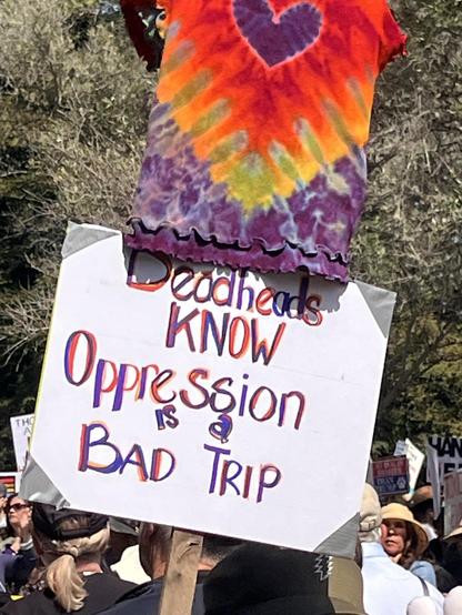At Hands Off rally in Santa Cruz a protester held a sign that said Dead Heads know that Oppression is a bad trip.  A tye dye shirt hung above it.
