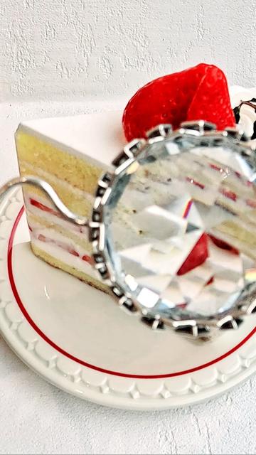 Strawberry cake viewed through the looking glass of the OPULENZ — eyewear designed by Xover0. The effect of the faceted gem lenses is somewhat blurred, blown-out, and kaleidoscopic.