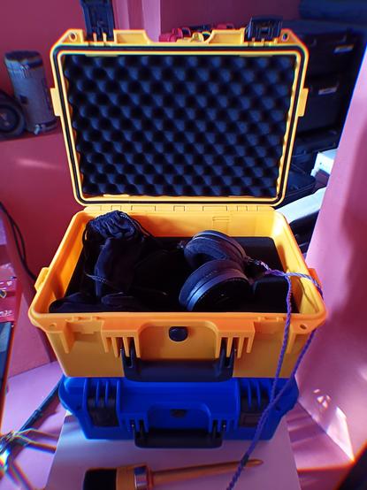Yellow and blue hard shell cases for my headphones. The yellow box is open, exposing my ATH-R70x by Audio Technica.