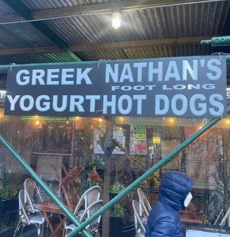 A photo of two fast food booths next to each other. One has a sign saying "Greek Yogurt", and the other sign says "Nathan's foot long hot dogs", but they're too close so it just looks like there is one sign saying "Greek Nathan's foot long yogurt hot dogs".