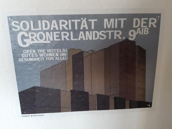 Palakt mit der Silhuette eines Wohnblocks;
Darauf steht "Solidarität mit der Groner Land Straße 9 a b. Open the Hotels. Gutes Wohnen und Gesundheit für alle!"