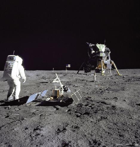 Aldrin by a lunar surface experiment with the LEM in the background.