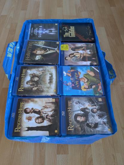 A large IKEA bag filled to the brim with Blu Ray movies, with almost no room left over.