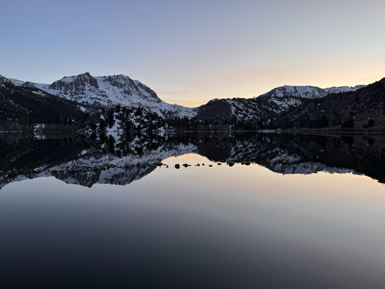 A sunset and mountains reflected in a lake
