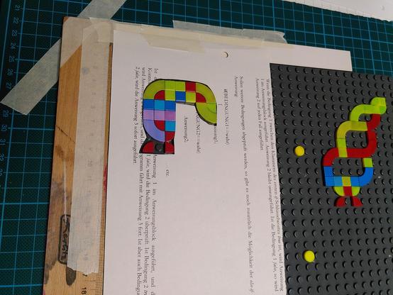 The mask should now cover most of the plate you do NOT want to print. I recommend taping the mask at one border to your desk.
(The wooden rulers visible are my register for the position of the lego plate. I'm still looking for better solutions)