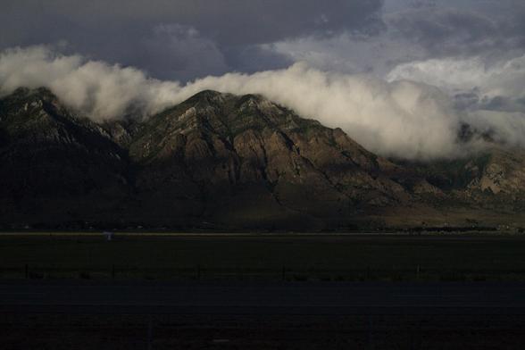 Mountains in the evening with clouds resting on top.