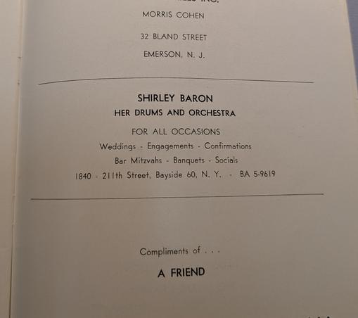 a closeup photo of an ad in an old publication.

"SHIRLEY BARON
HER DRUMS AND ORCHESTRA
FOR ALL OCCASIONS
Weddings - Engagements - Confirmations. 
Bar Mitzvahs - Banquets - Socials
1840 - 211th Street, Bayside 60, N.Y. - BA 5-9619"