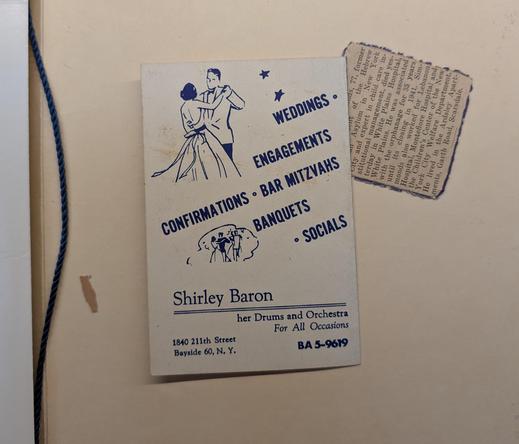 photo of the backside of a small pamphlet with clipart of people dancing and info about Shirley Baron , drummer and orchestra leader.