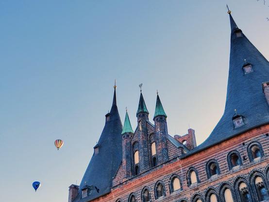 Holstentor mit Heißluftballons in der Abendsonne.