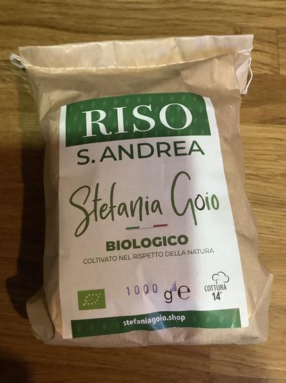 Eine papierene Reisverpackung mit grün/weißer Beschriftung: Riso S. Andrea Stefania Goio Biologico.