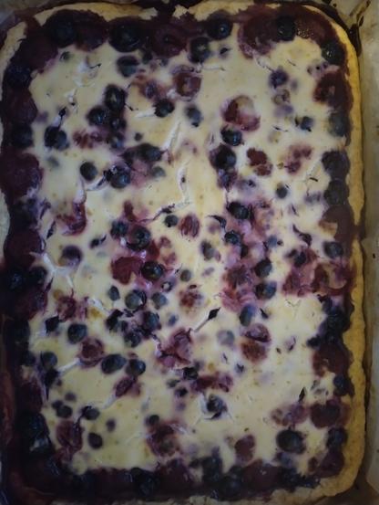 Suorakaiteen muotoinen mustikka-vadelmapiirakka, jossa soijajogurttikuorrutus.