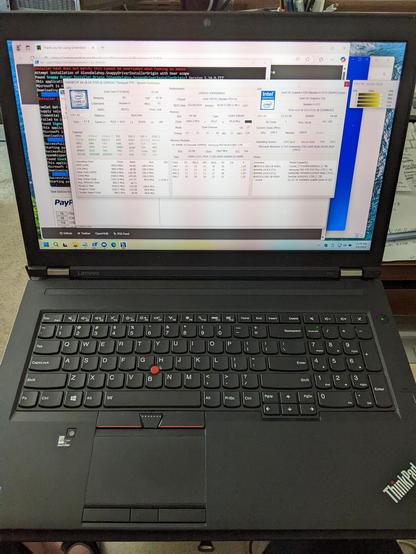 A ThinkPad P70 workstation laptop, in the process of being rebuilt: Windows 11 having bin installed, now installing all the applications. The HWiNFO application is displayed on the screen, showing the specifications of the laptop.