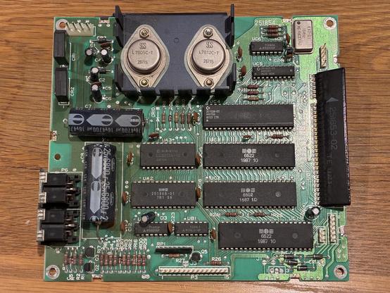 A square green PCB with a handful of large ICs, two big electrolytic caps and two metal can voltage regulators.