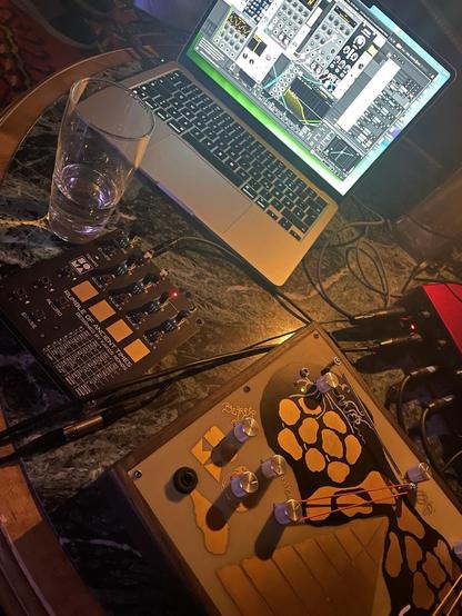 Old table dark marble and Wood, with Apple macbookair vcv rack on, sims enner and roat, candle light