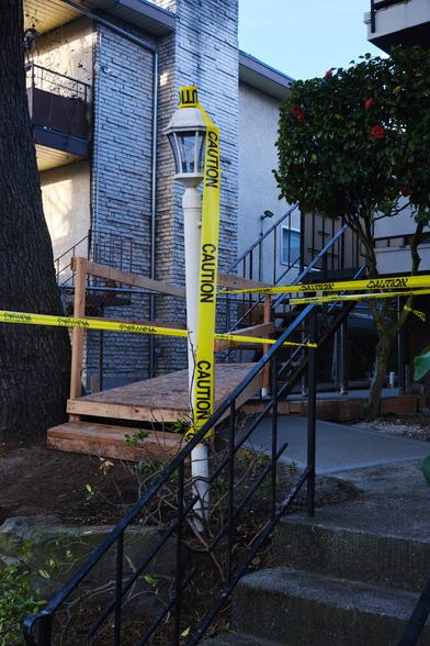 Caution tape wrapped around a residential lamp post.