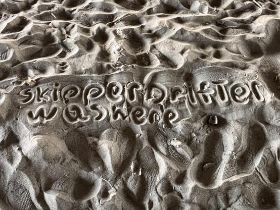 Writing in sand that says Skipper Drifter was here. Skipper Drifter is my teenage son's online handle.