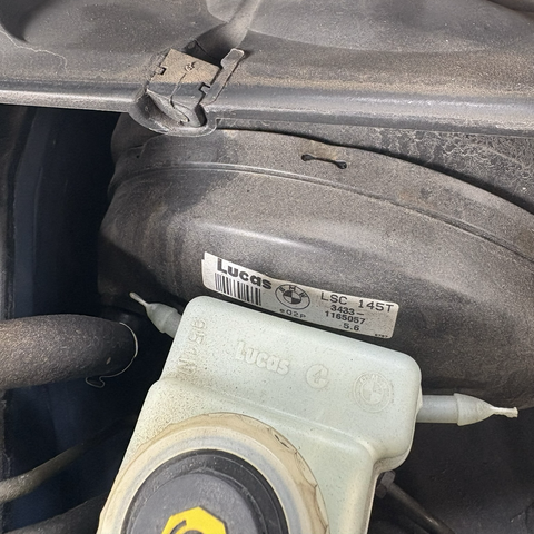 The brake booster and fluid reservoir under the hood of my 2003 BMW 525iT, both of which bear the maker's mark of Lucas Industries, England's notorious supplier of questionable automotive electronic components.