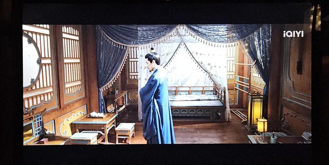 The owner of the tower ship standing in his cabin, that mostly ressembles a room in a Chinese villa, with decorative screen windows and a bed under a silk canopy.