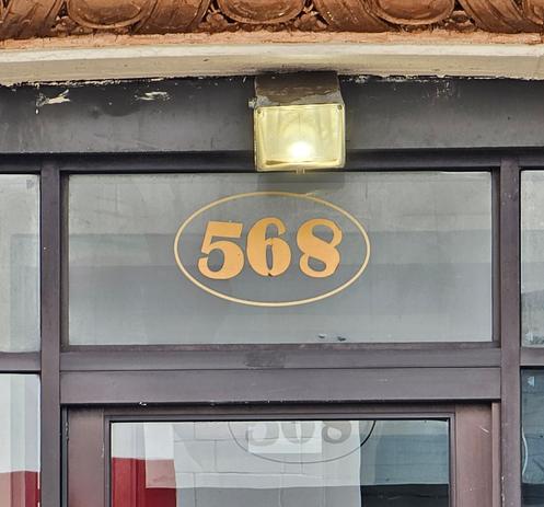 Photgraoh of 568 painted on glass above a doorway. The 5 leans forward to the top right. The 8 is update dkwn. Thd 6 looks like it could be an upside down 9, or a 6.