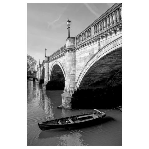 Black and white photo showing Richmond Bridge in the background and a skiff on the water in the foreground