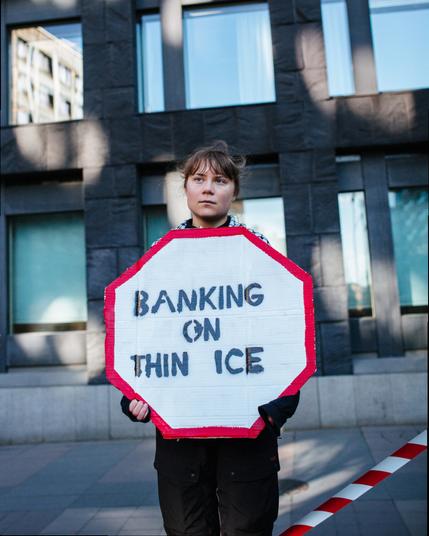 Greta standing with a placard saying "Banking on thin ice".