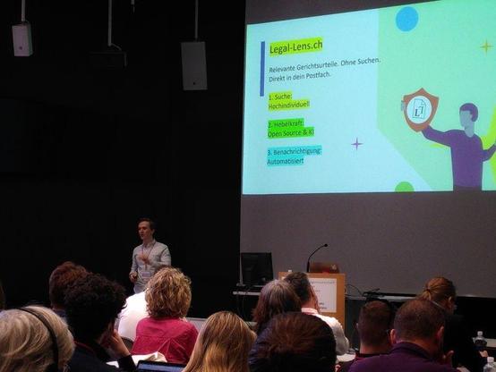Timothy presents in front of a large audience at the Hackathon in Magglingen